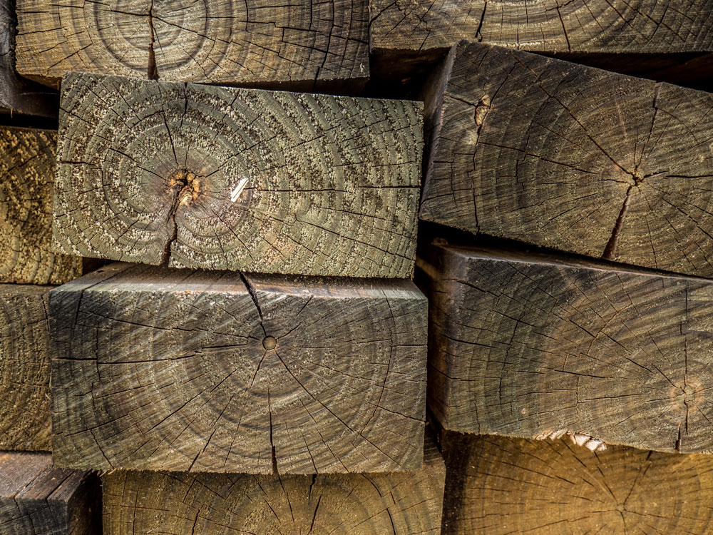 A stack of wooden railway sleepers in a pile.