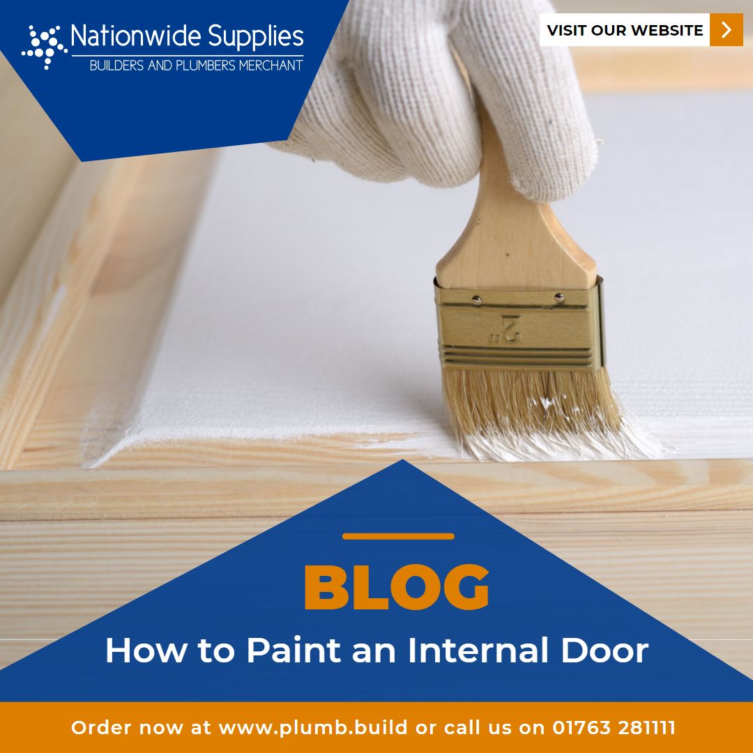 a gloved hand paints a plain wooden panelled door white.